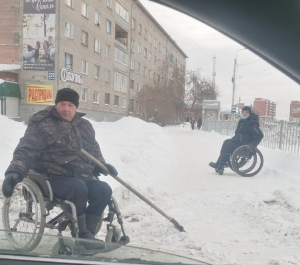 Инвалиды-колясочники чистят территорию вокруг общежития по улице Советской